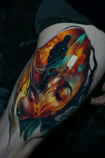 abstract human silhouette and face colour realism tattoo on thigh