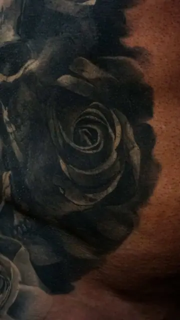 black and grey rose and skull tattoo on chest