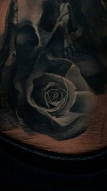 black and grey skull and rose tattoo on neck