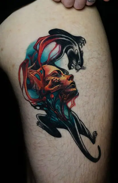 colour fantasy head and panther tattoo on upper arm