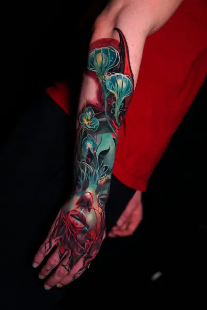 colour realism abstract face and glowing plants full arm tattoo