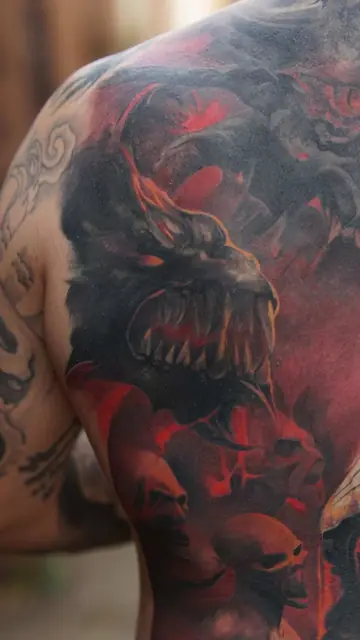 colour realism demon head and skulls tattoo on shoulder and back