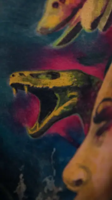 colour realism snake head and partial face tattoo