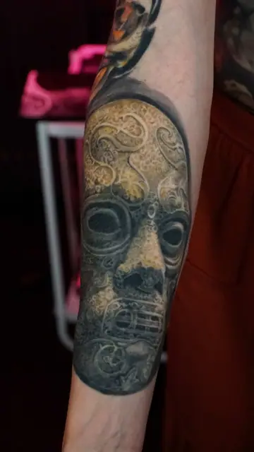 colour realism stone mask tattoo on forearm