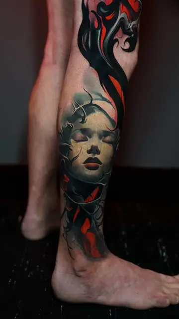colour realism woman's face with smoke/fire tattoo on lower leg
