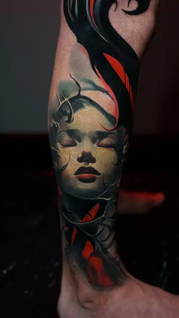 colour realism woman's head tattoo on lower leg
