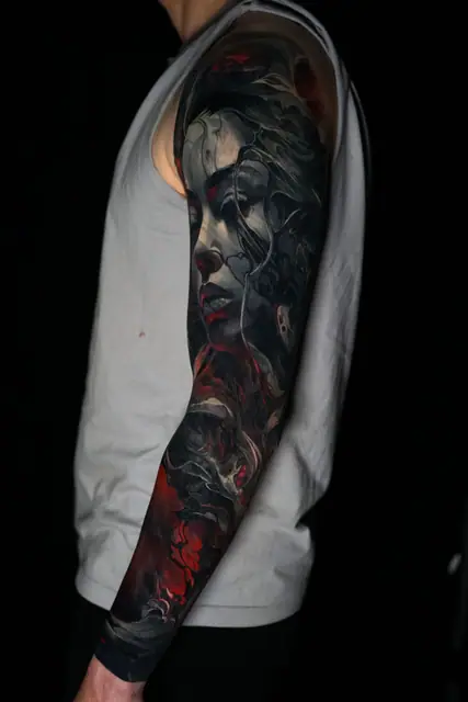 dark realism woman's face and abstract sleeve tattoo