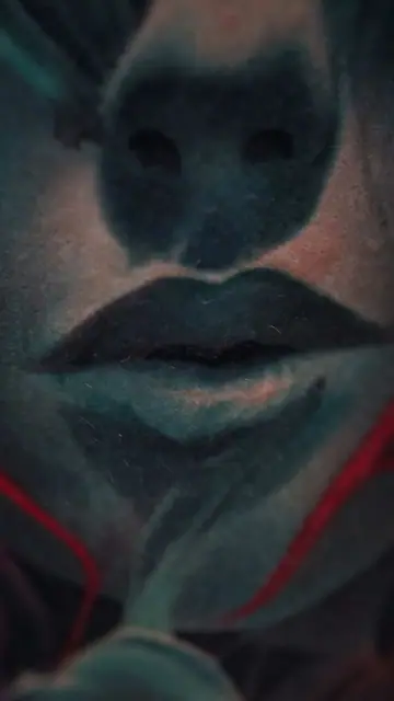stylized dark blue face tattoo, red details, on chest