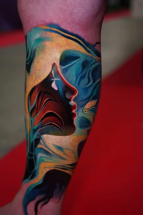 abstract colour realism blue and orange flowing face tattoo on lower leg