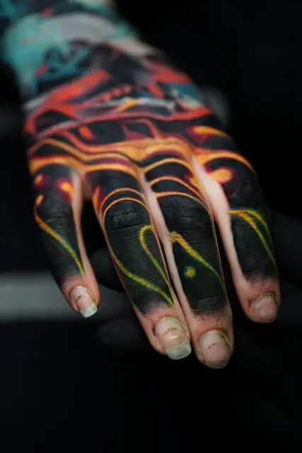 abstract glowing colour tattoo on hand and fingers