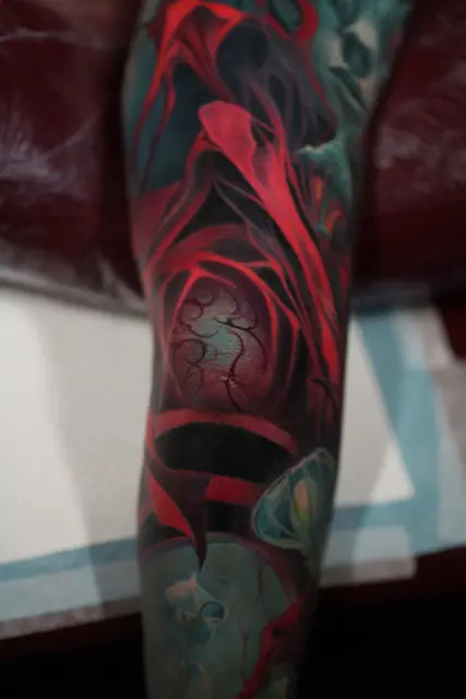 abstract red and blue colour tattoo on leg