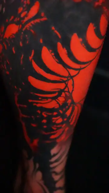 blackout red leaves tattoo on arm