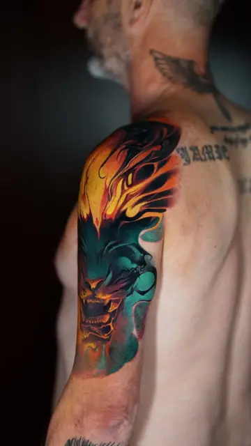 colour illustrative beast head tattoo on upper arm shoulder