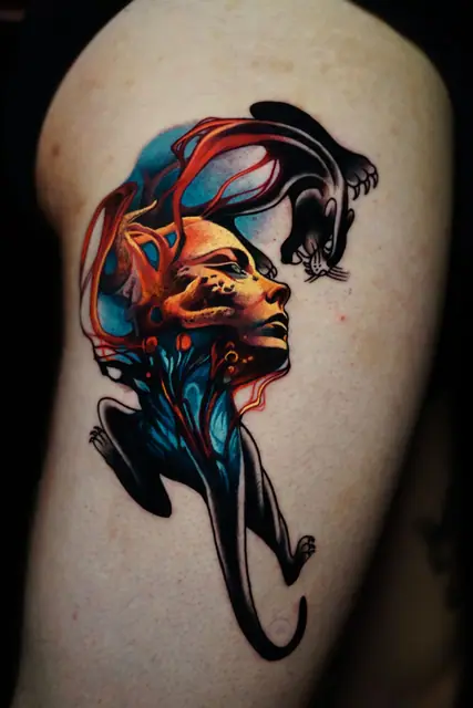 colour realism abstract face and panther tattoo on upper arm