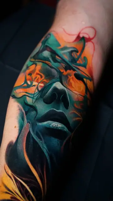 colour realism abstract face tattoo on forearm