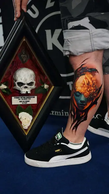 colour realism abstract face tattoo on lower leg