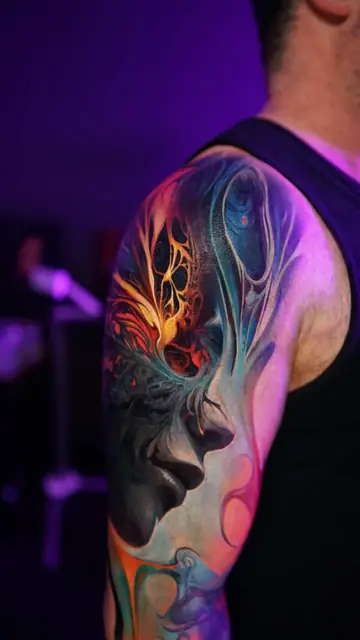 colour realism abstract face tattoo on upper arm