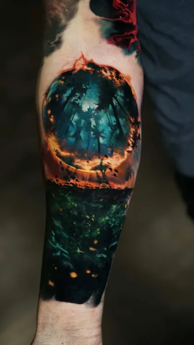 colour realism burning forest and fireflies tattoo on forearm