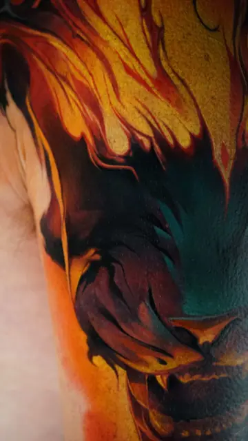 colour realism dragon head with flames tattoo on upper arm