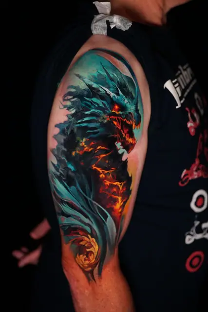 colour realism dragon tattoo on upper arm with fire and teal scales
