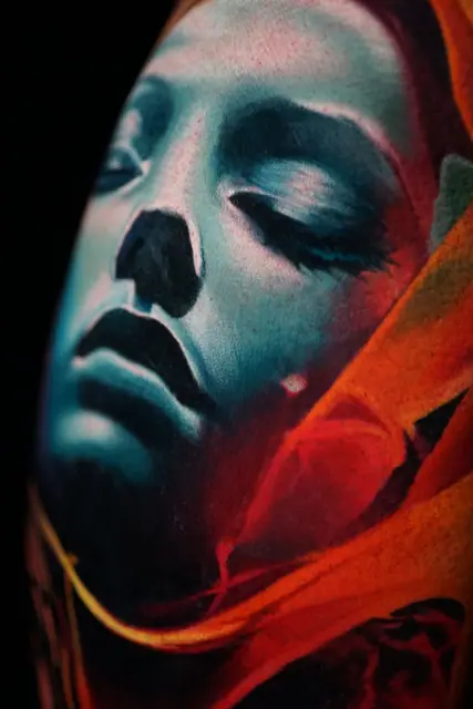 colour realism ethereal woman's face tattoo on body, red fabric