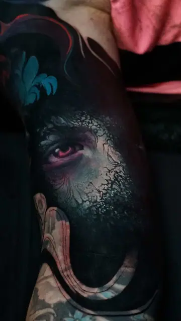 colour realism eye and fleur-de-lis tattoo on upper arm