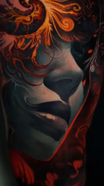 colour realism face profile with fiery elements tattoo on upper arm