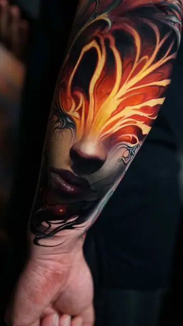 colour realism fire-face portrait tattoo on forearm