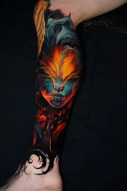 colour realism glowing face tattoo on lower leg