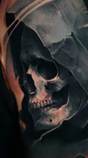 colour realism hooded skull tattoo on upper arm