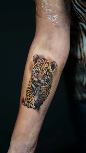 colour realism jaguar cub tattoo on forearm