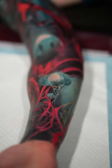 colour realism jellyfish tattoo with red accents on forearm
