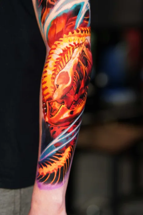 close-up of fiery phoenix feather detail tattoo on forearm