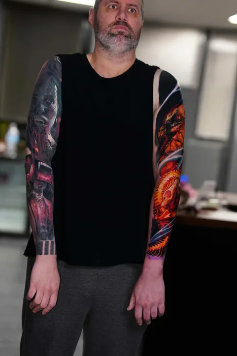 client standing showing completed colour realism phoenix sleeve tattoo
