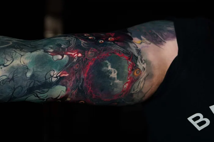 colour realism red moon and smoke tattoo across inner arm