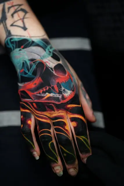 colour realism skull and lava tattoo on hand and fingers