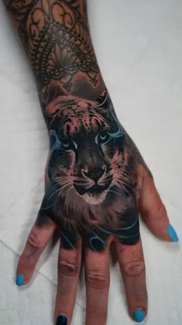 colour realism tiger face tattoo on hand, with mandala on forearm