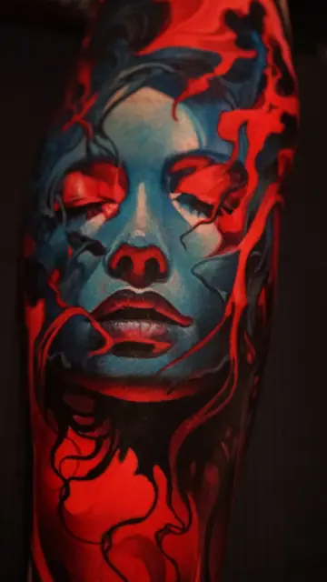 colour realism woman's face tattoo with red and blue on arm