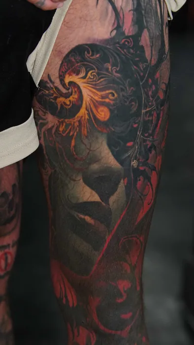 dark colour realism face in smoke tattoo on thigh
