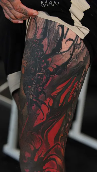 dark red and black abstract thigh tattoo