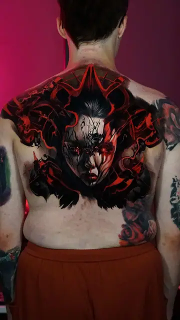 demonic red and black portrait tattoo on full back