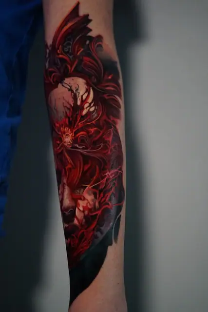 red abstract demonic face colour realism tattoo on forearm