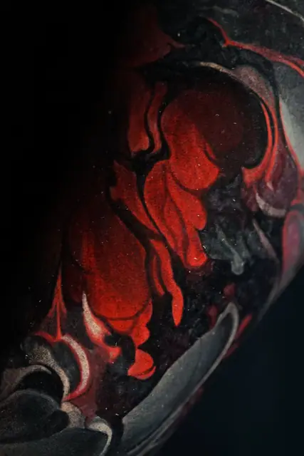 red and black demonic abstract tattoo on arm